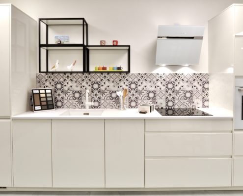 Façades laquées blanc brillant, plan de travail en compact 20 mm Finitop, électroménager Bosch, hotte Elica, évier sous plan et mitigeur Blanco